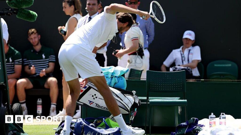Daniil Medvedev smashes his racquet after losing his first-round match at Wimbledon