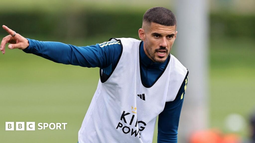 Conor Coady points with his right hand during a Leicester City training session